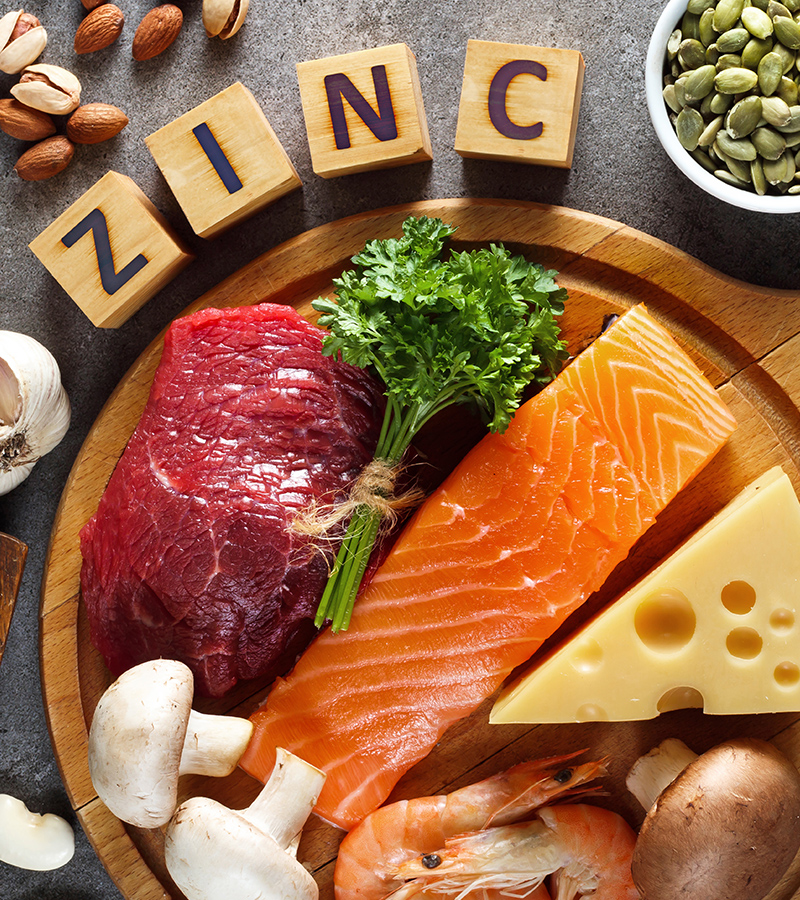Zinc and Fresh Food Fresh Food that are high sources of zinc, to include salmon, tuna, mushrooms, cheese, onions, and shrimp on a plate with toy blocks spelling out zinc sitting around it.