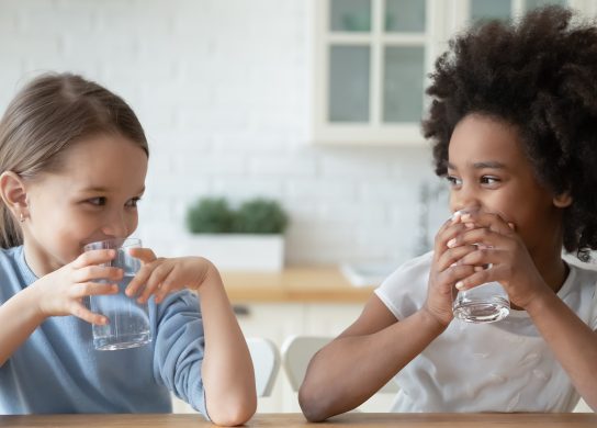 Hydration. Image of two girls drinking water