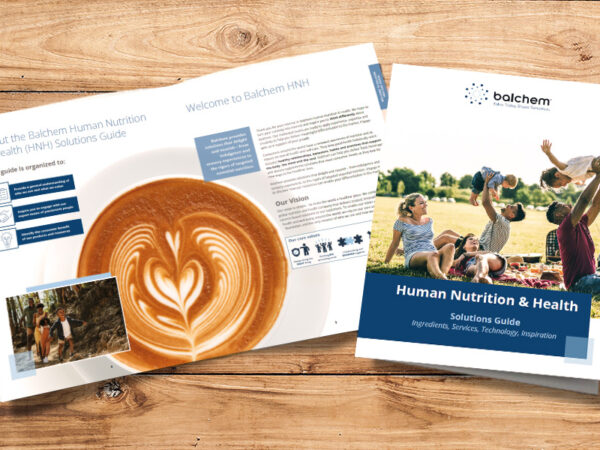 A picture of the Balchem Human Nutrition and Health Solution Guide sitting on a wooden background.