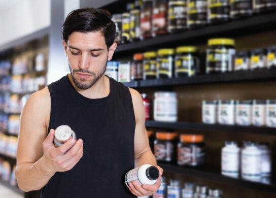 Image of a man comparing supplement bottles