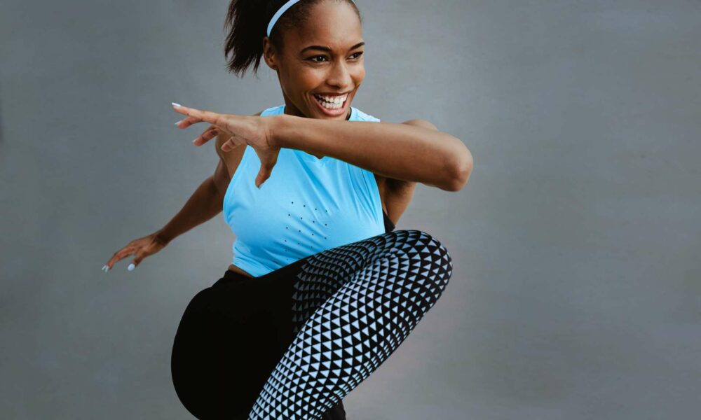 Woman stretching in a blue shirt and leggings