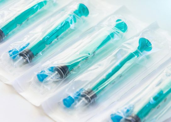 Blue syringes lined up in packaging