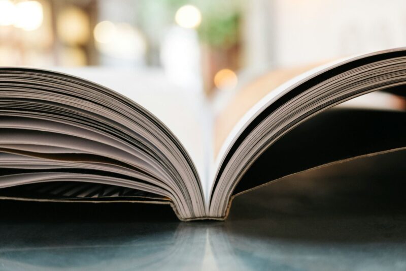 Open book with fanned pages on a table.