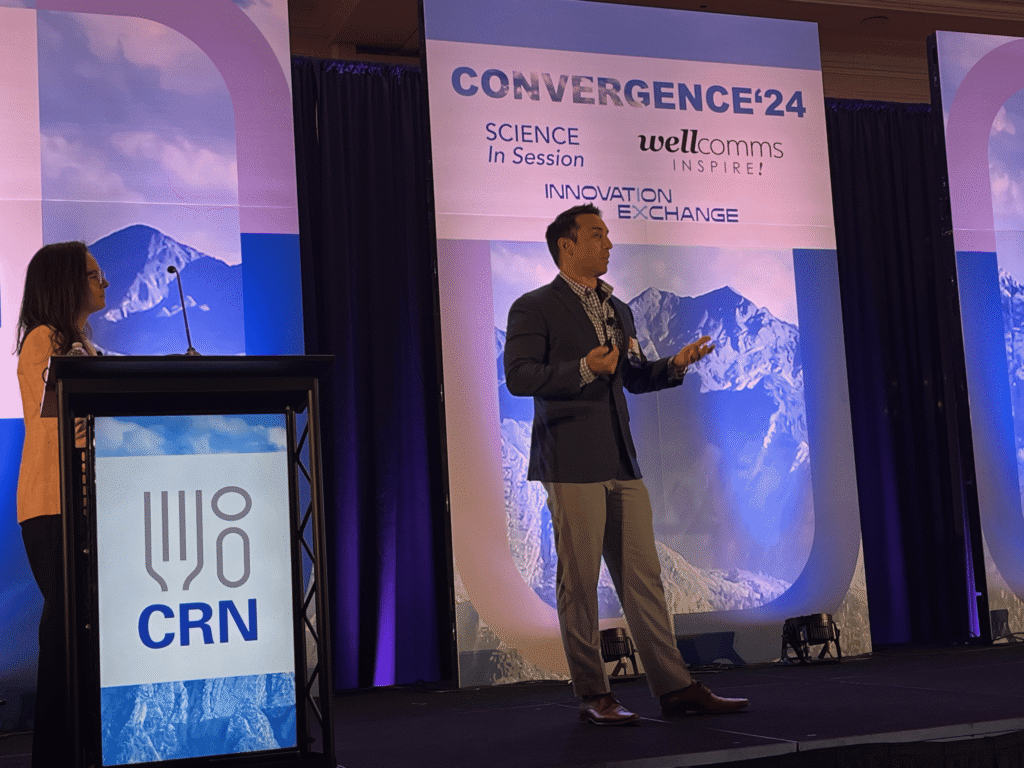 Man and woman speak at conference with mountain backdrop.