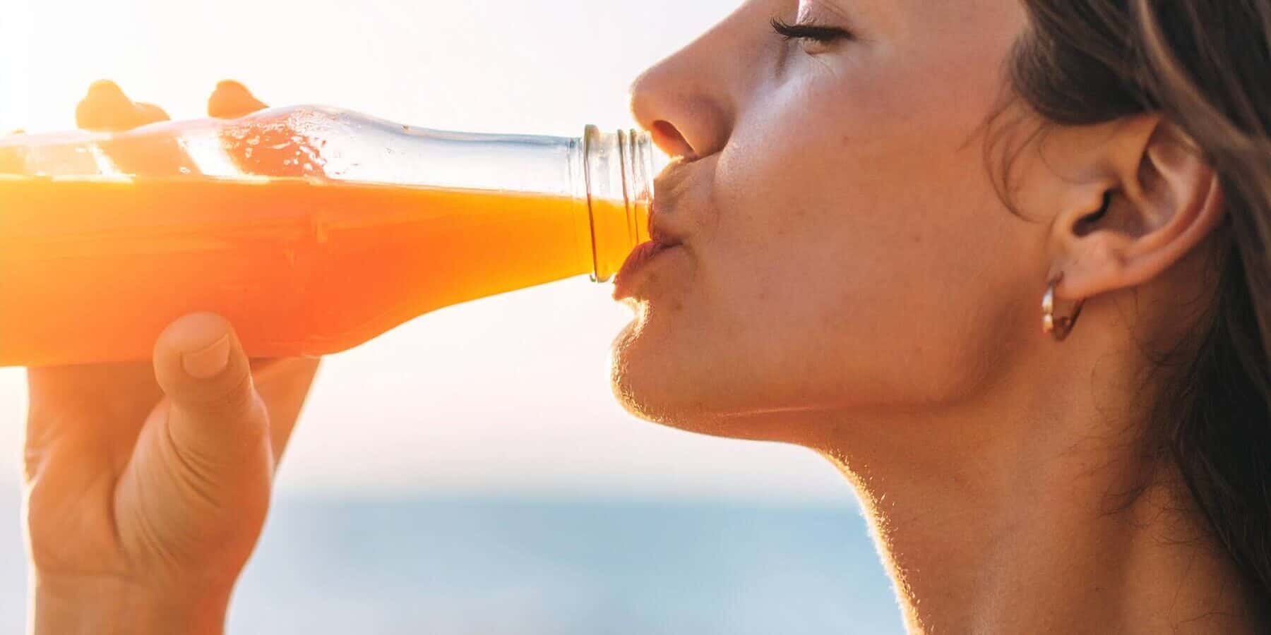 Image of a woman drinking out of a glass bottle