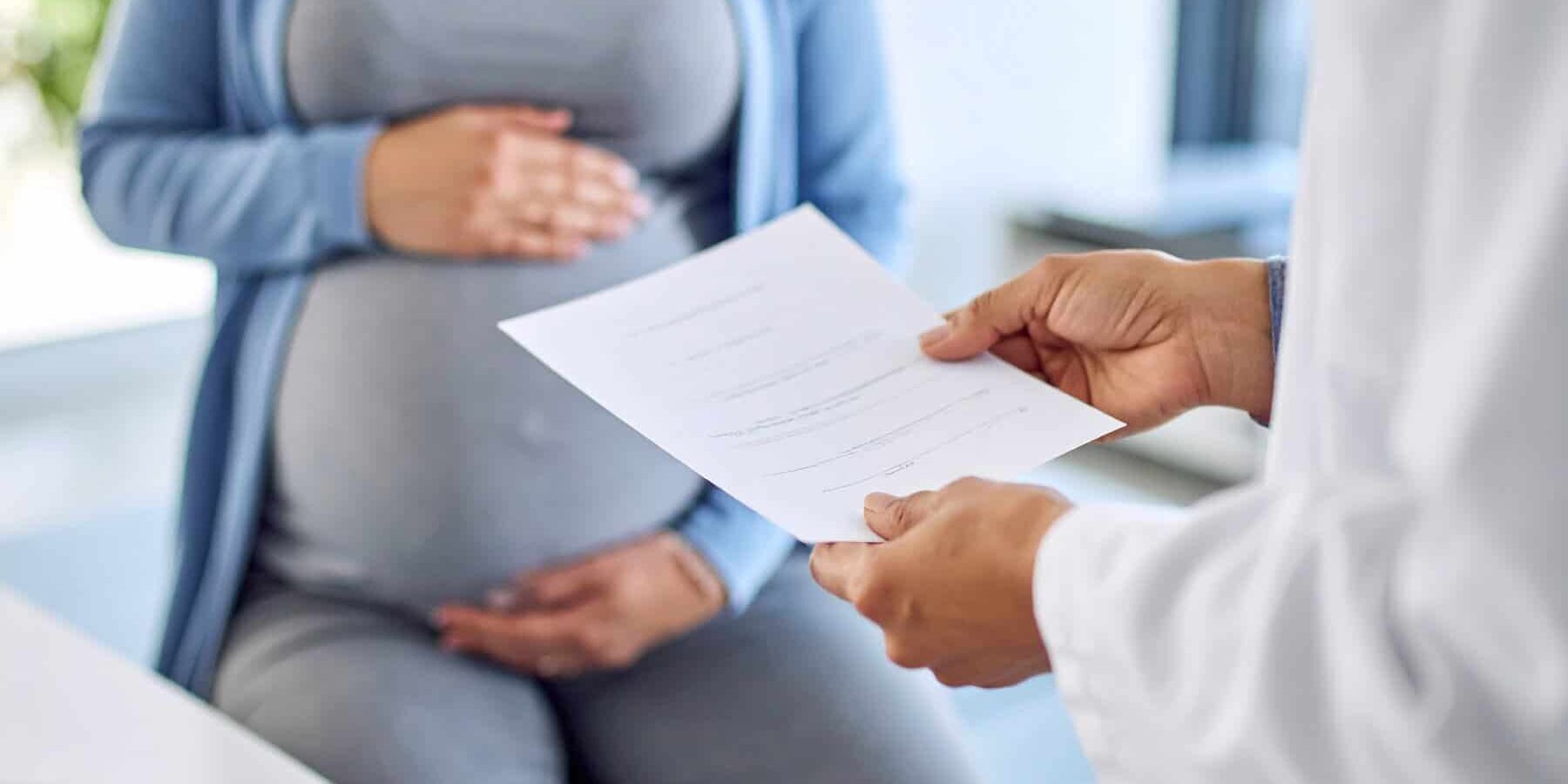 image of a woman receiving a report while pregnant