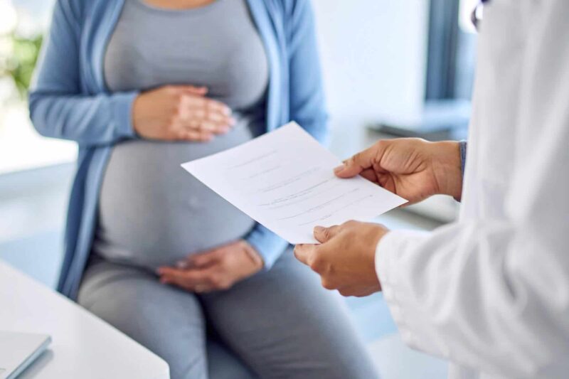 image of a woman receiving a report while pregnant