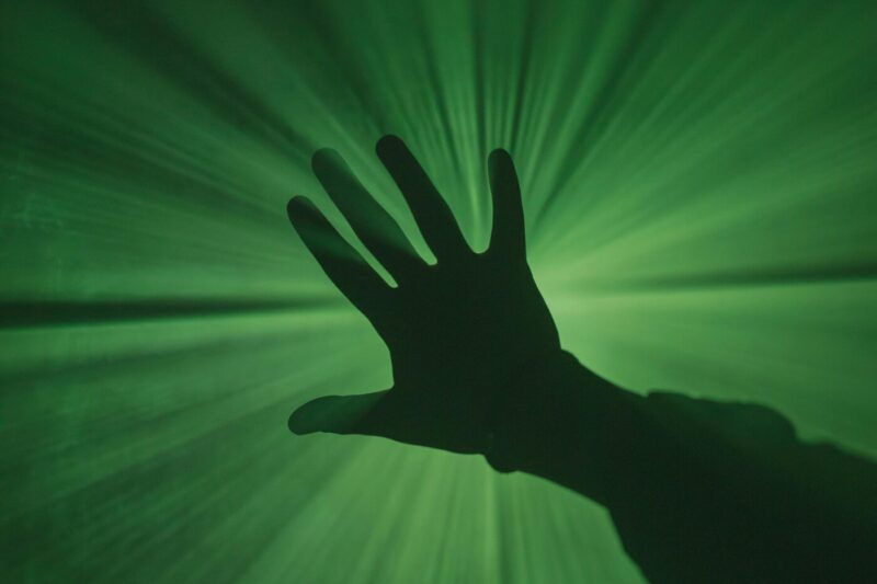 hand in green light glow