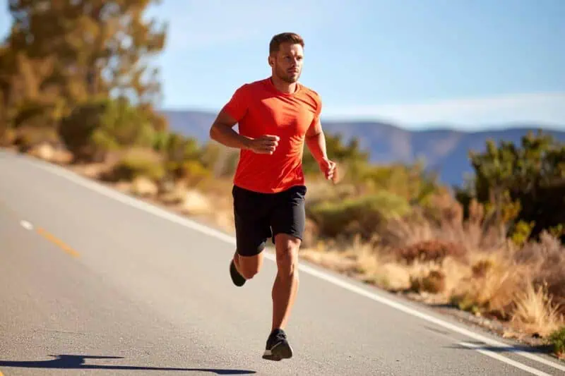 image of a man in a salmon shirt running downhill