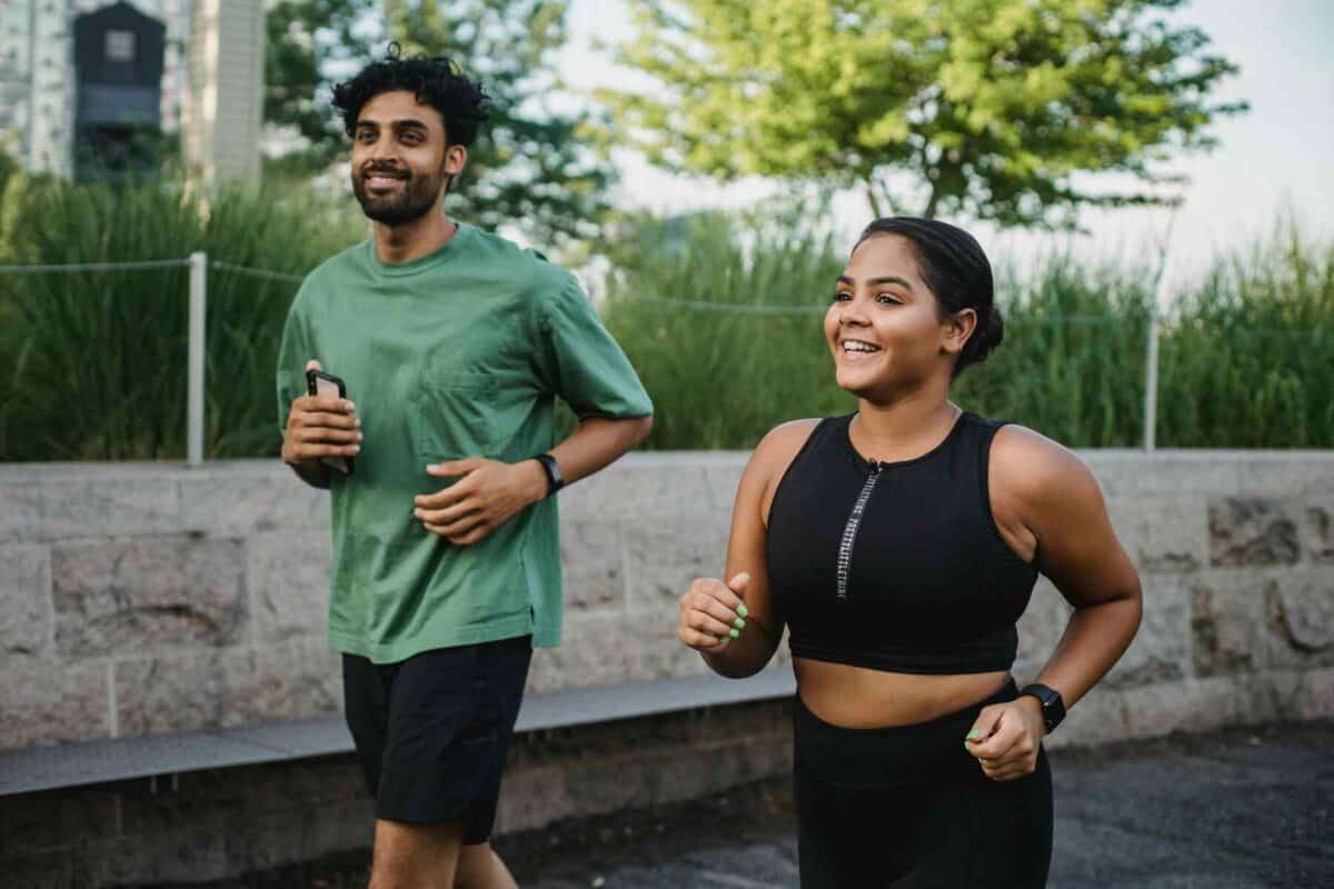 happy couple jogging in a green park