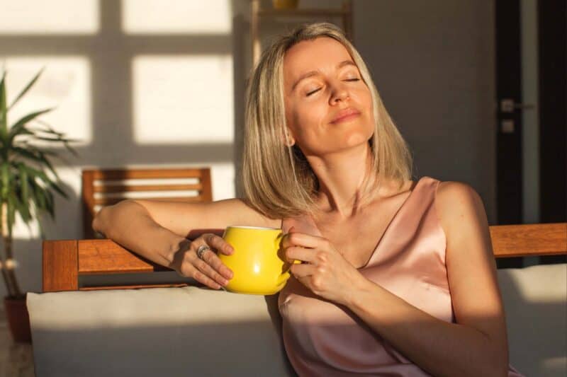 Image of a woman sitting with a yellow coffee mug