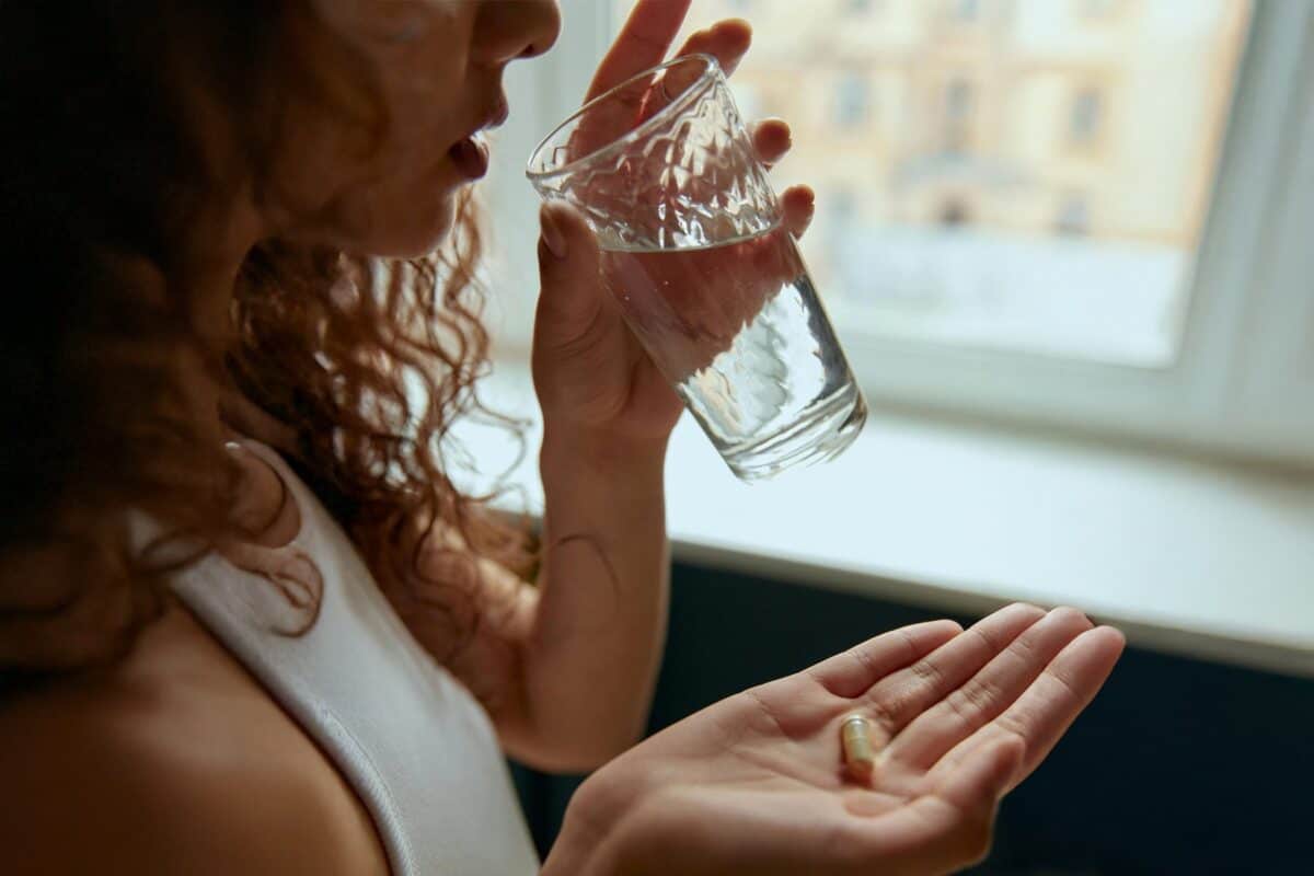 woman-pill-stabilipro_1800x1200 Image of a woman taking a pill with a glass of water