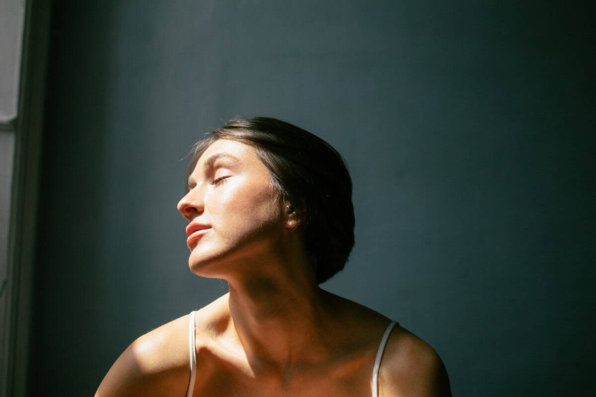 Image of a woman sitting with the sun hitting her face