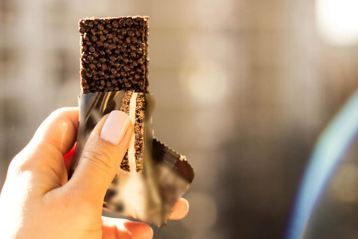 Snacking Teaser Image 1200x800px Image of a hand with a protein bar
