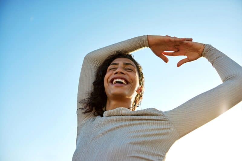 woman-in-sun_1801x1201 Image of a woman in the sun with her hands above her head.