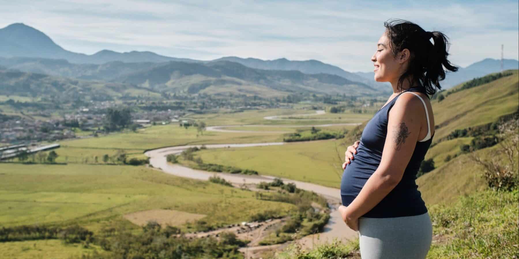 Image of a pregnant woman on a hike on a hill