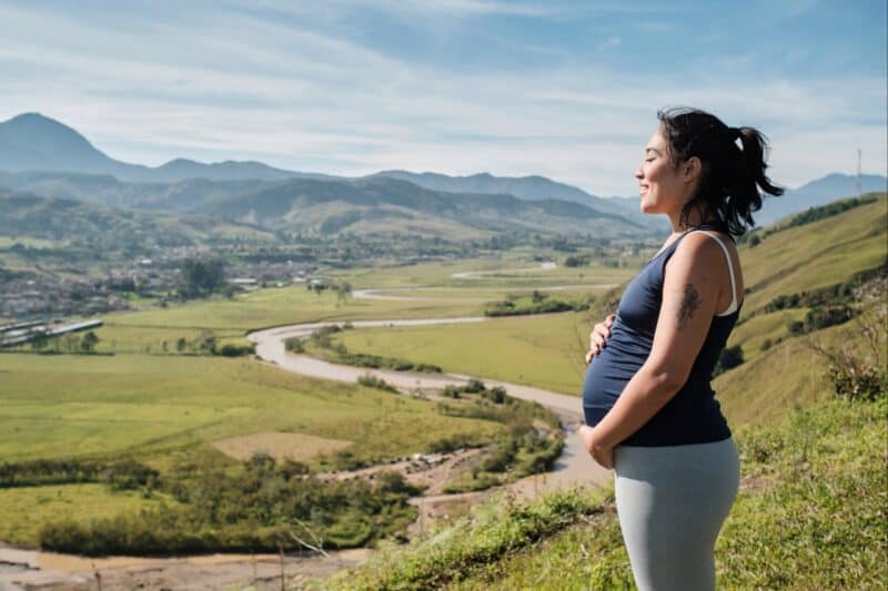 Image of a pregnant woman on a hike on a hill