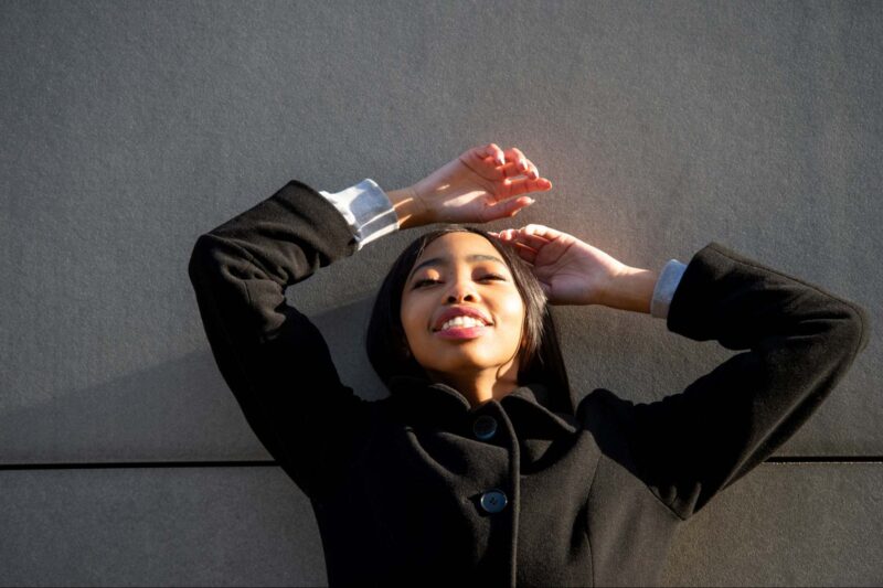 Image of a woman on her back with a black coat on.