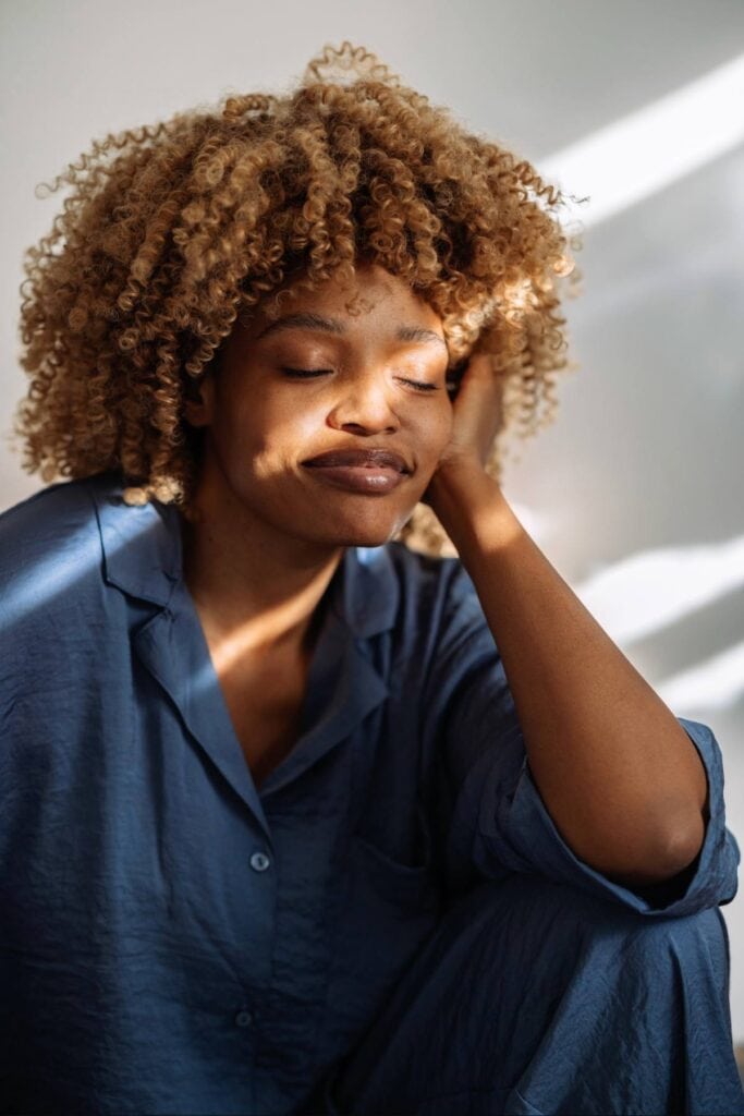 Image of a woman sitting with light hitting her face