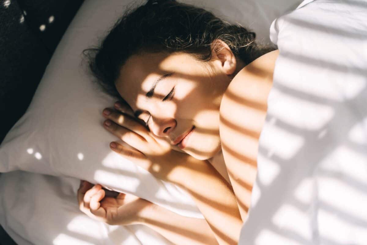 Image of a woman asleep with white sheets