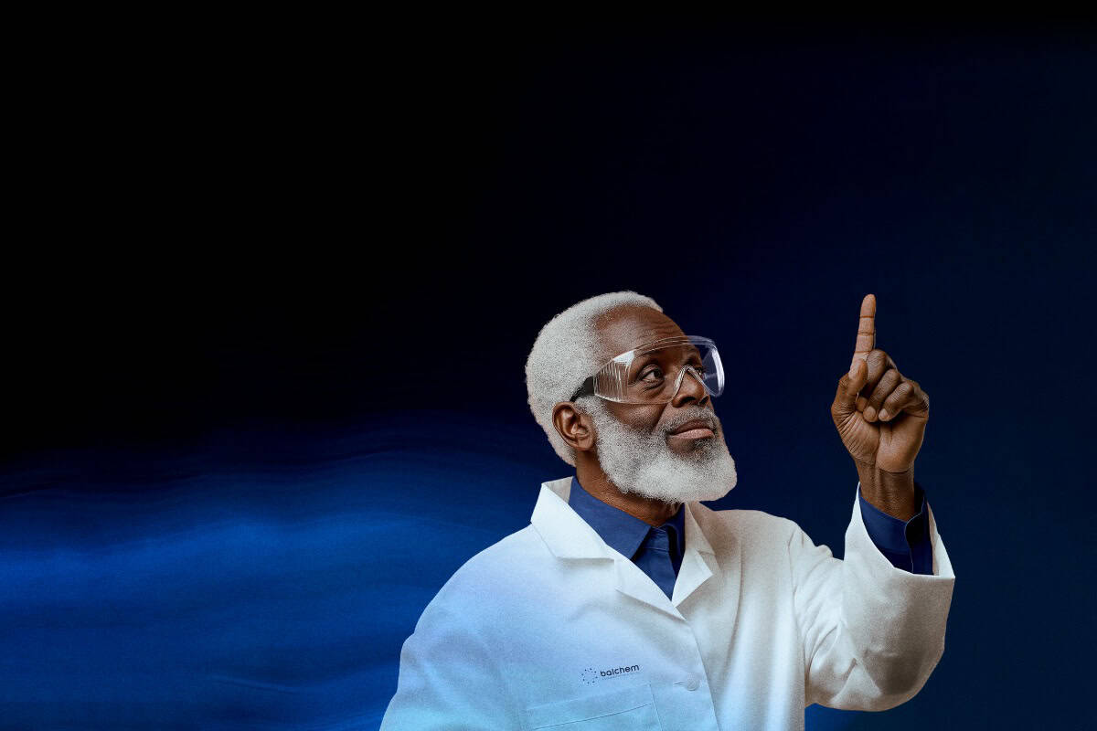 man in a lab coat and glasses pointing up