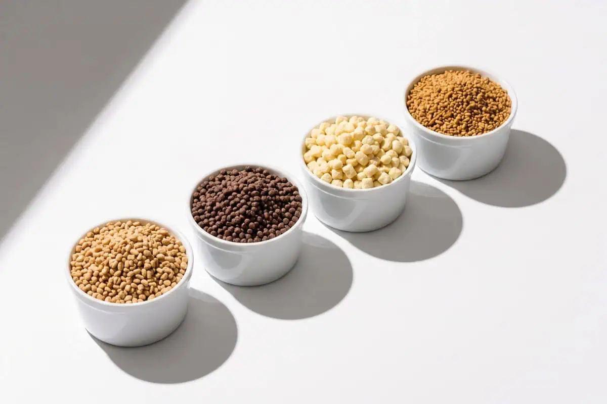 Assorted nutritional ingredients in white bowls on a white surface.