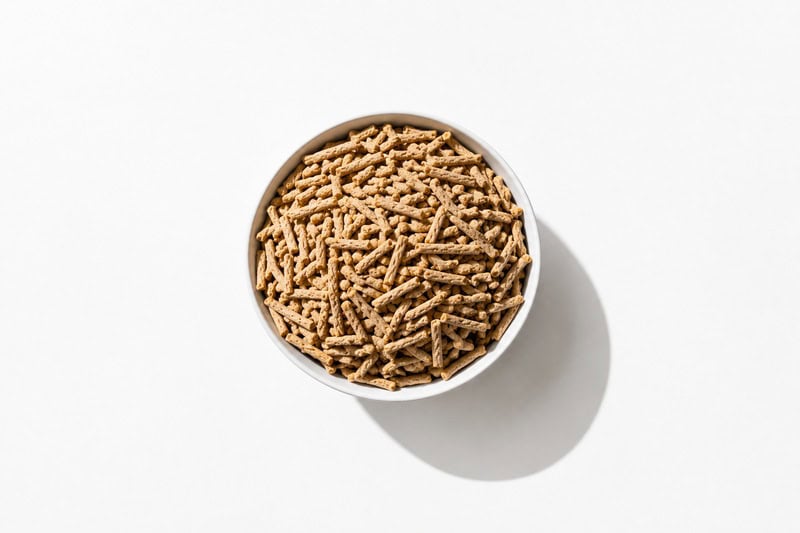 Bowl filled with fiber cereal pieces on a white surface